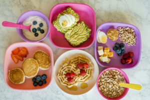 Several plates of breakfast foods for kids
