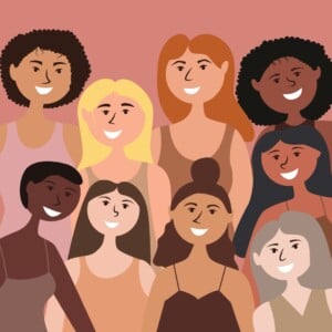 An illustration of nine women with different skin tones, hair colors, and hairstyles, standing together and smiling. The background is a warm pink color. All are wearing sleeveless tops in various shades of pink and brown.