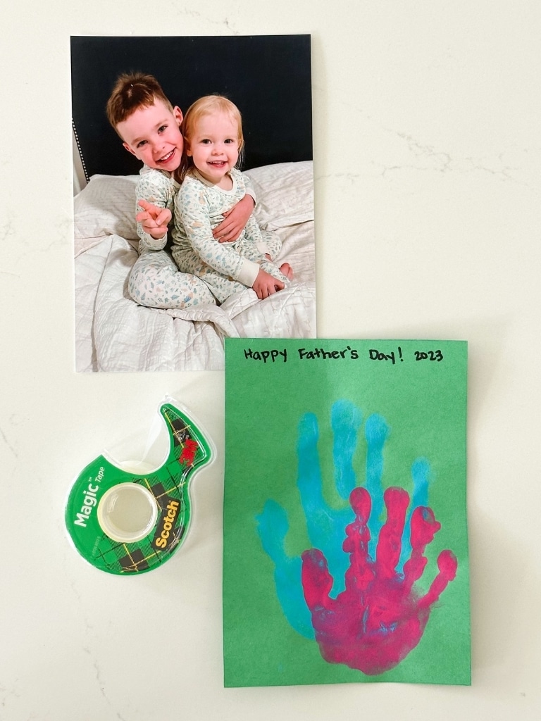 Kids' picture with handprint picture and a roll of Scotch tape