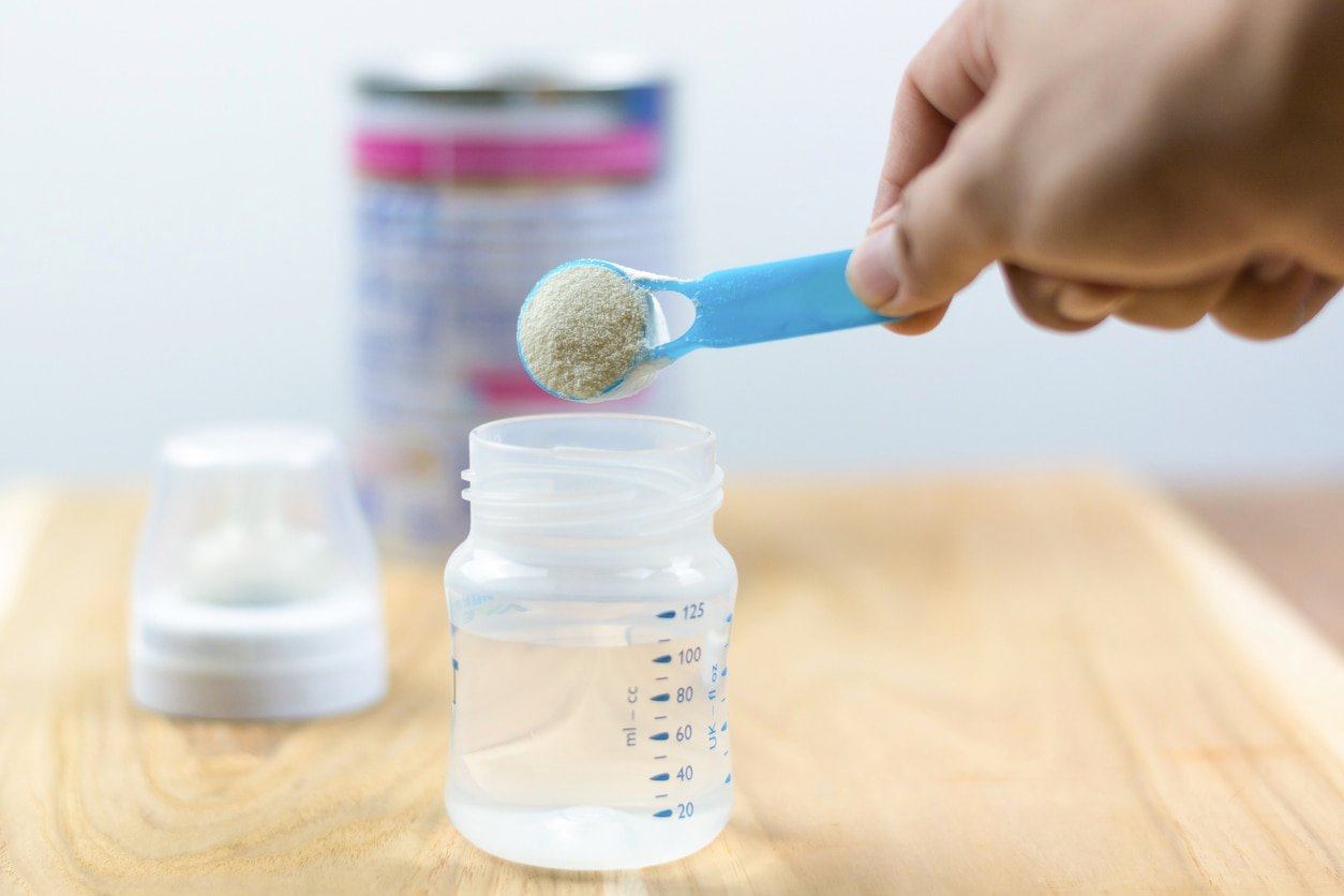Infant formula milk using a measuring spoon Powdered milk with a spoon for babies Infant formula and bottle