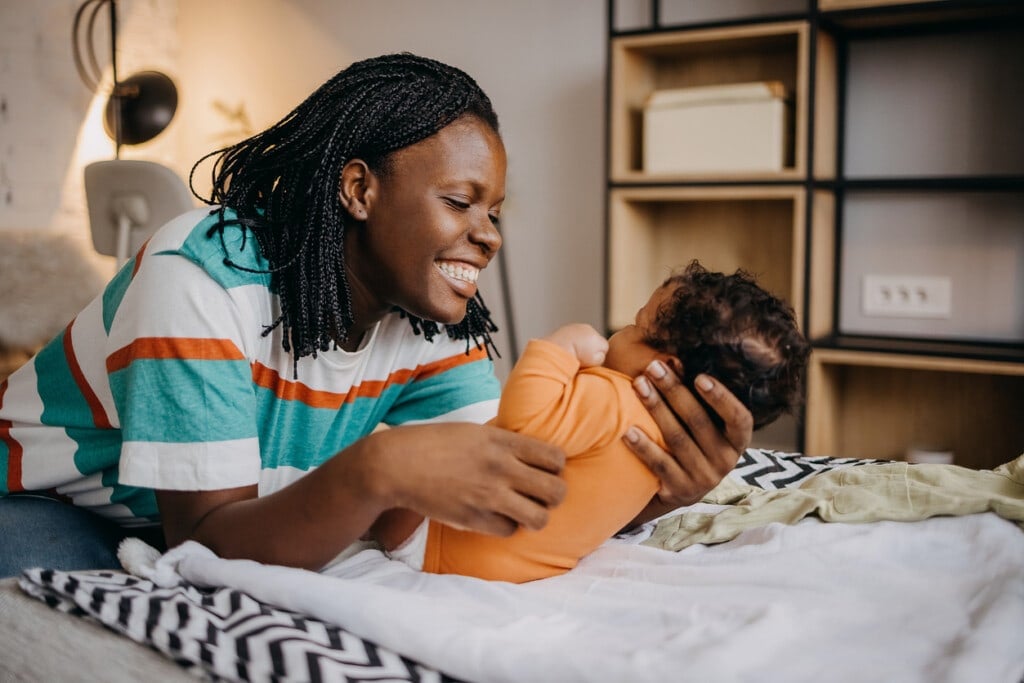 Shot of a young woman playing with her adorable baby on the bed at home