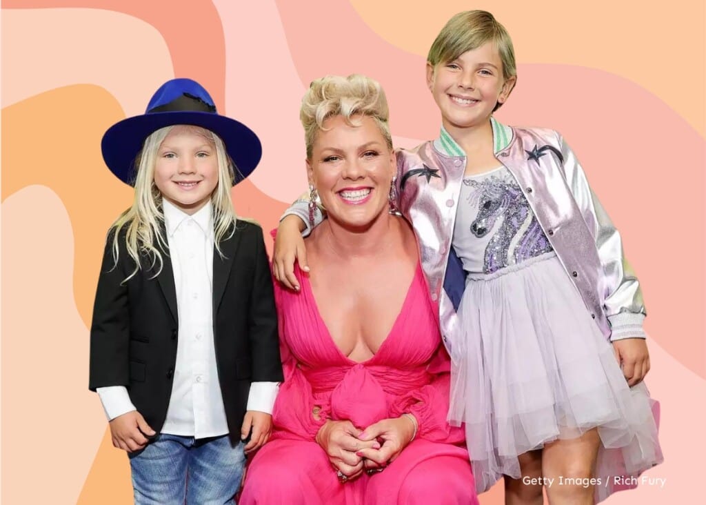 Pink squatting down with her kids smiling at the camera