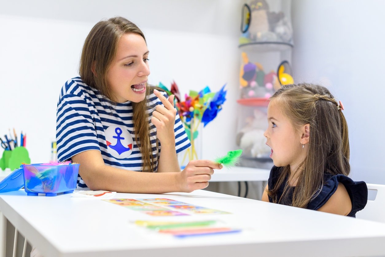 Children speech therapy concept. Preschooler practicing correct pronunciation with a female speech therapist.