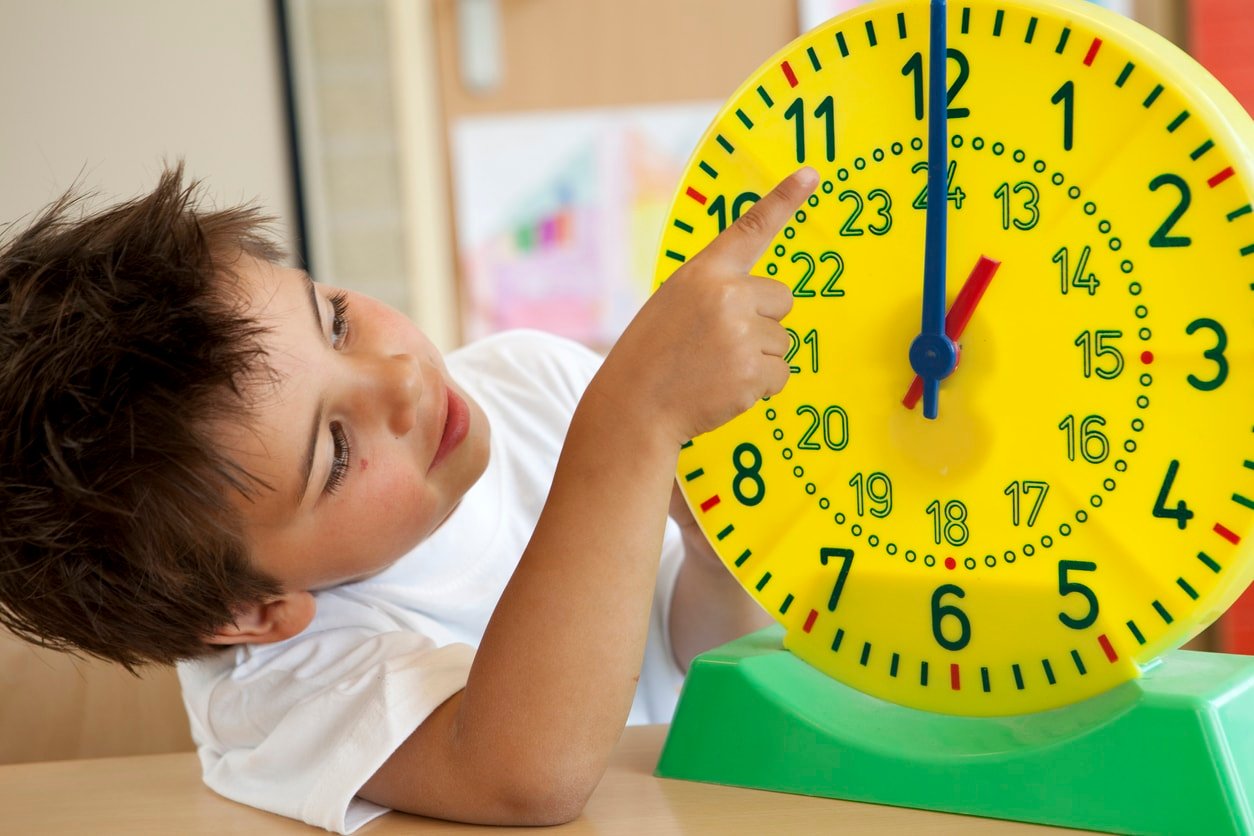 Little boy learning the clock and how to tell time.