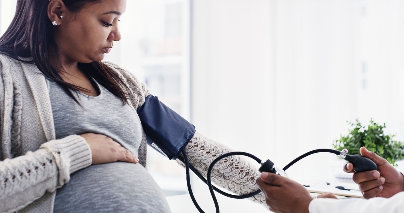 Shot of a pregnant young woman getting her blood pressure checked by a doctor at a clinic