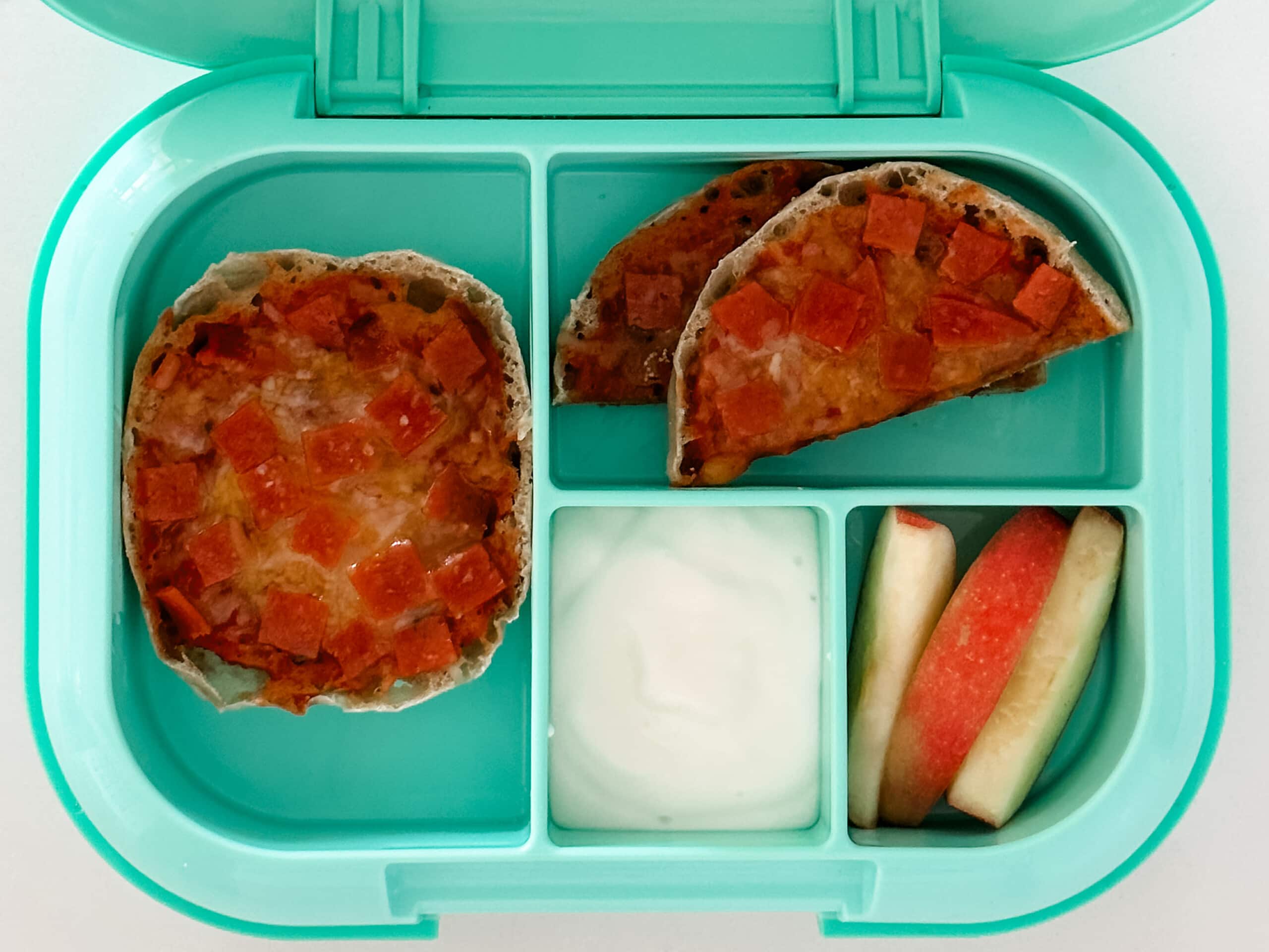 Mint green bento box for kids filled with english muffin pizza, apple slices, and yogurt
