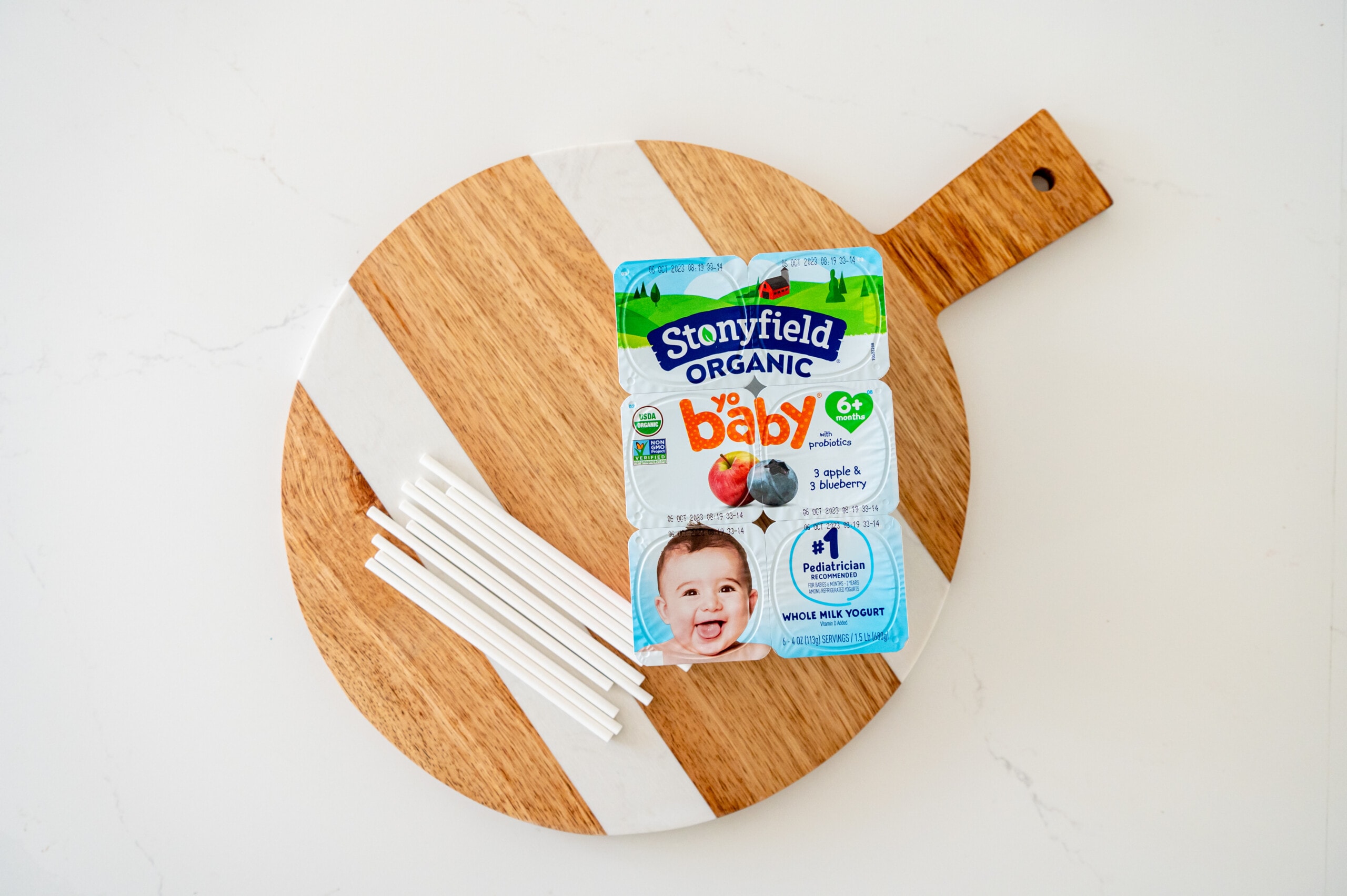 Stonyfield Yobaby yogurt and cookie sticks on a cheese board