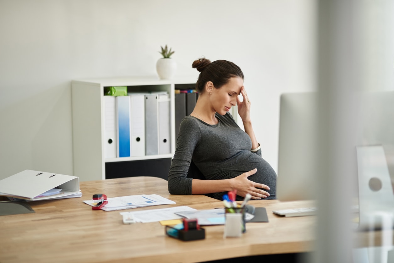 Shot of a pregnant businesswoman in discomfort in her office