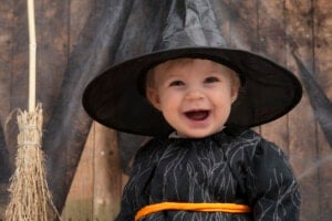 baby dressed as a cute little halloween witch