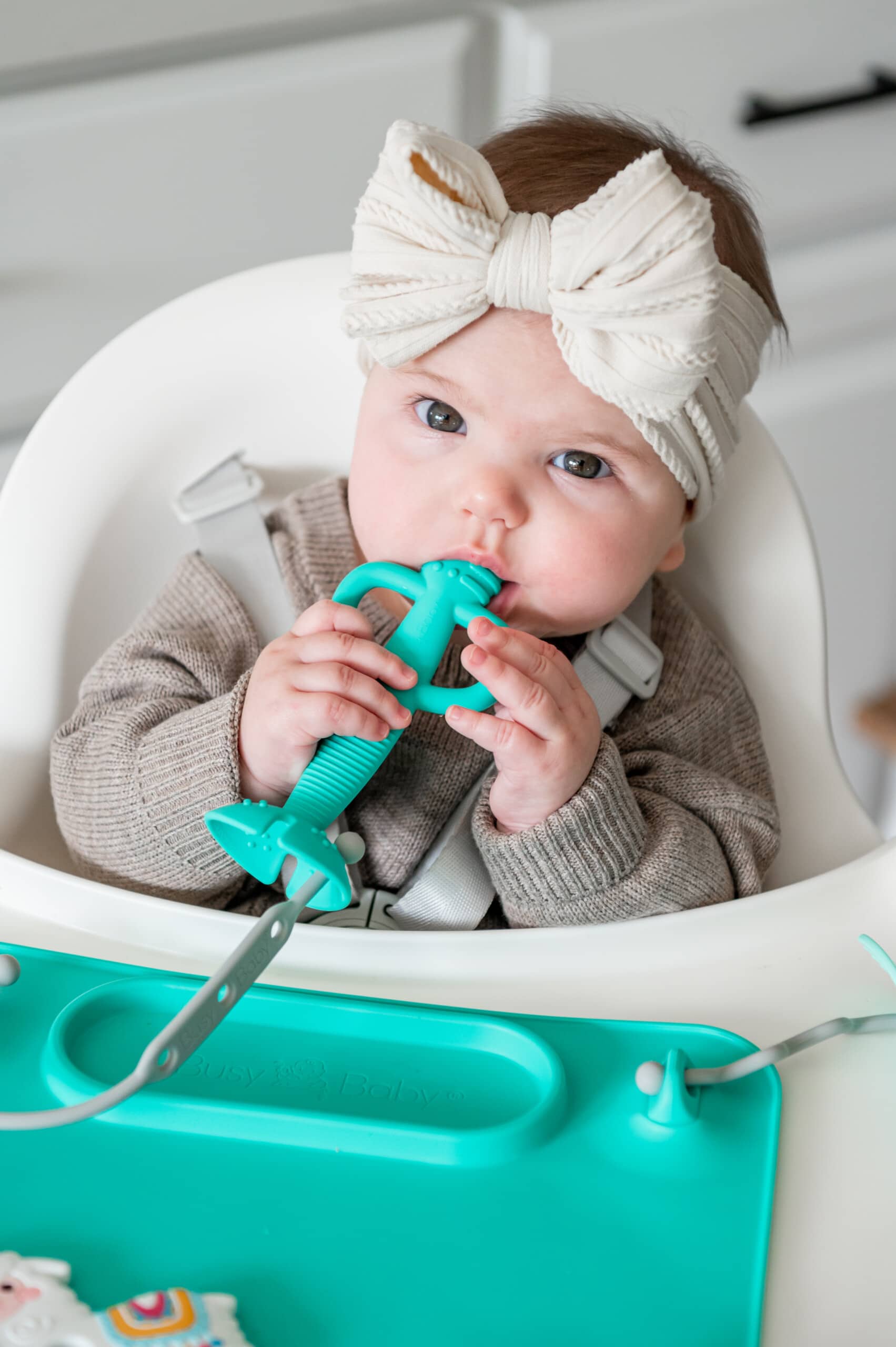 Baby girl teeting on the Busy Baby teething spoon