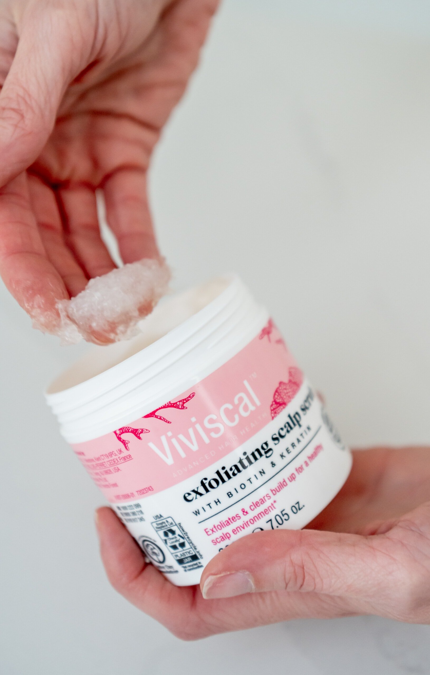 Hand scooping out some of the Viviscal exfoliating scalp scrub