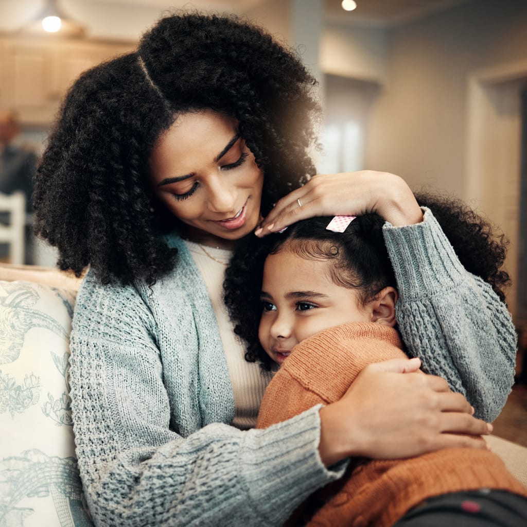 Family, love or kid hug mother for Mothers Day, home bonding or embrace on living room couch. Care, custody and biracial mom, mama or woman with female youth child, girl or daughter on apartment sofa