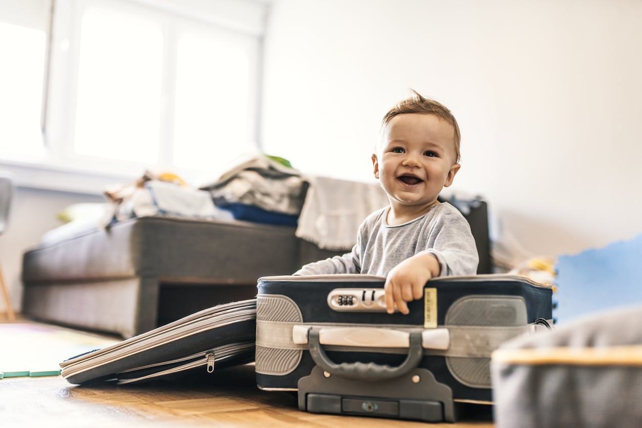 Adorable Baby Boy In Suitcase Having Fun. Photo of Adorable Caucasian Baby Boy In Suitcase Having Fun in hotel room, Getting Ready For Traveling. Concept travel. a happy funny boy child with suitcase.