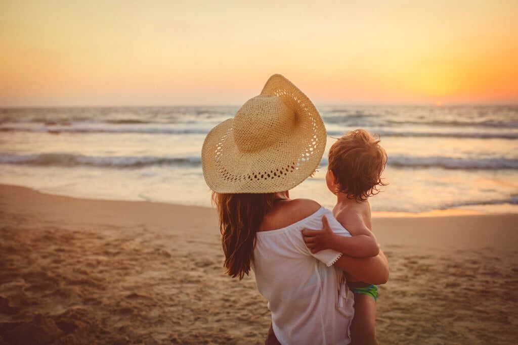 Mother with son enjoying sunset on the beach