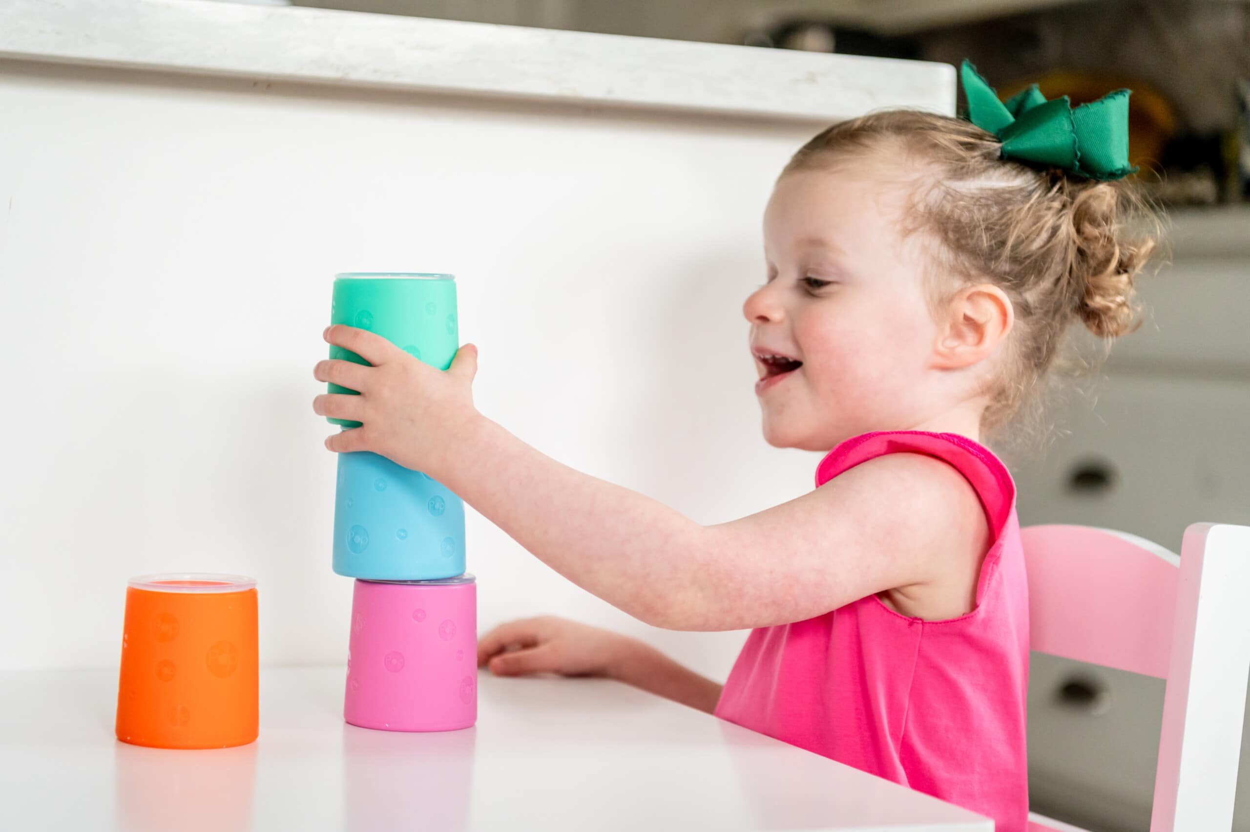 Little girl stacking the PopYum toddler cups