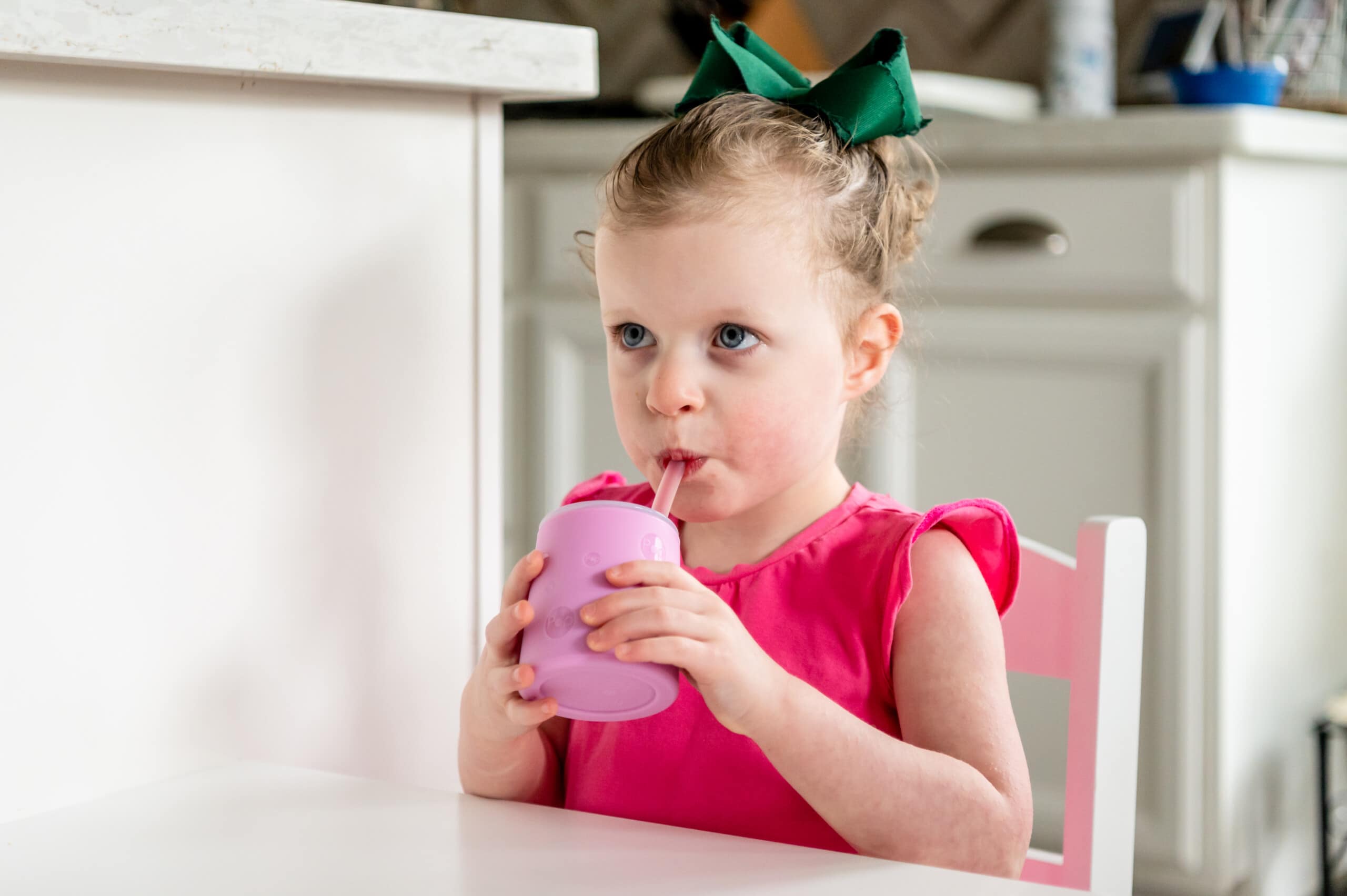 Toddler girl drinking from PopYum silicone cup