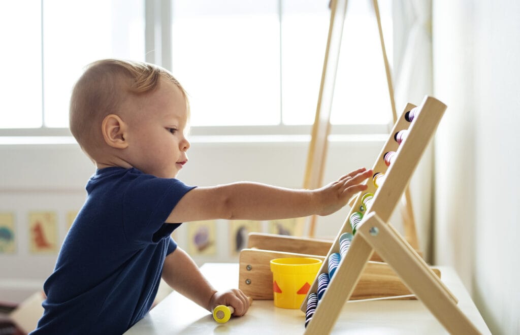 Little boy playing abacus for counting practice