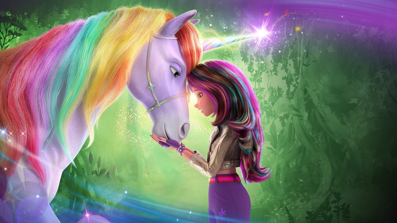 A young girl with long, multicolored hair places her forehead against the forehead of a white unicorn with a rainbow-colored mane and tail. Both are surrounded by a magical, glowing aura in a lush, green forest background—it's like stepping into a scene from your favorite "what to watch" list. Unicorn Academy.