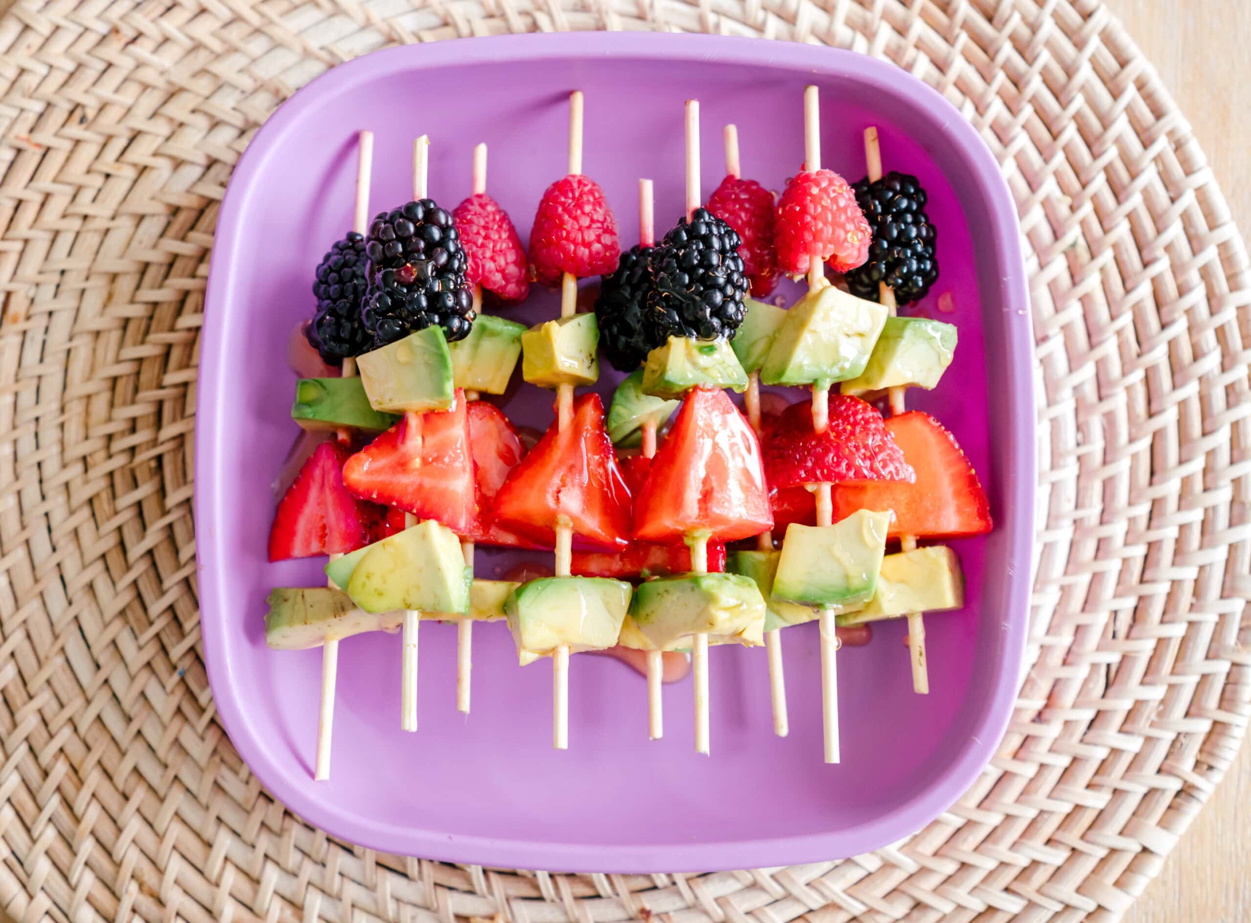 Avocado and berry snack on skewers on kids plate