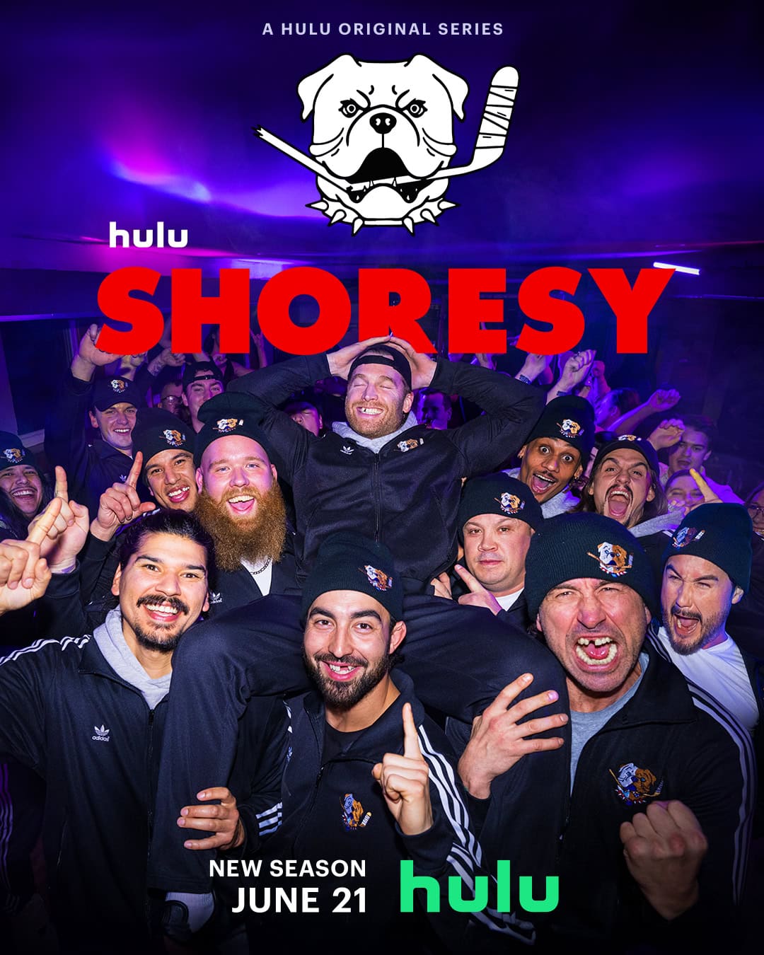 A group of men in athletic clothing celebrate enthusiastically in a dimly lit environment. If you're wondering *what to watch*, the Hulu original series "Shoresy" has you covered with its new season premiering June 21. The series logo, featuring a bulldog with crossed hockey sticks, is displayed at the top.