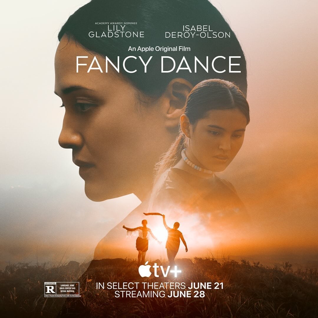 Poster for the film "Fancy Dance," featuring a large profile of a woman's face in the background and a smaller image of another woman looking down. Below them, two people hold hands and raise their arms against a sunset. Discover what to watch with release dates for theaters and streaming prominently displayed.