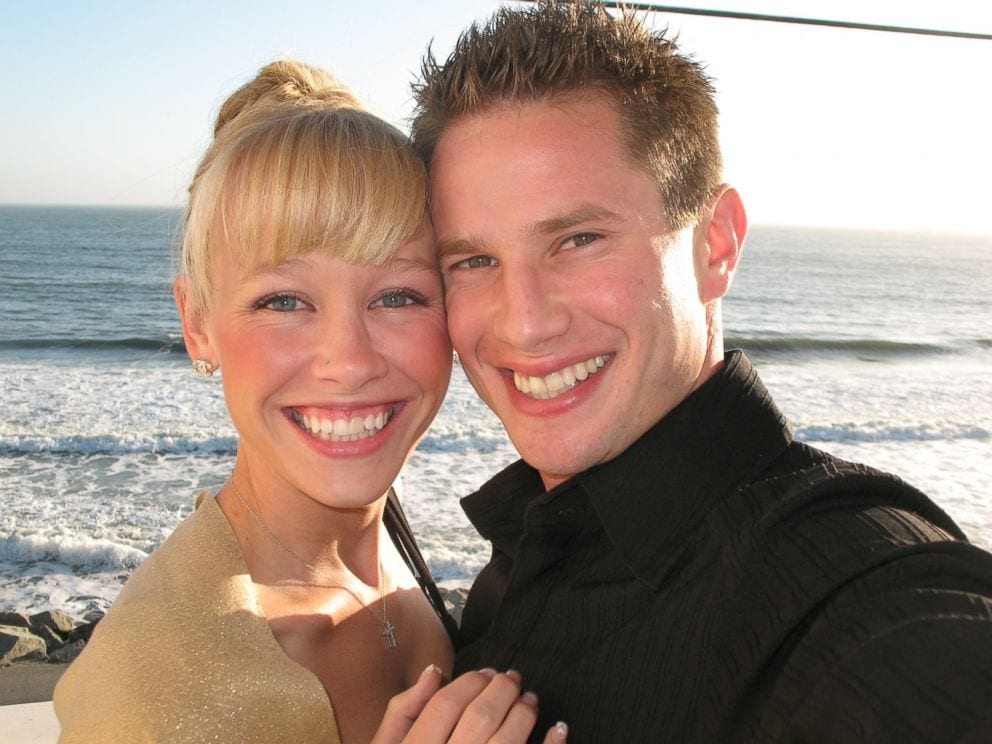 Sherri Papini. A smiling woman with blonde hair and a man with short brown hair take a close-up selfie on a beach, perhaps discussing what to watch later. The woman wears a light-colored top, and the man wears a black shirt. The ocean and waves are visible in the background.