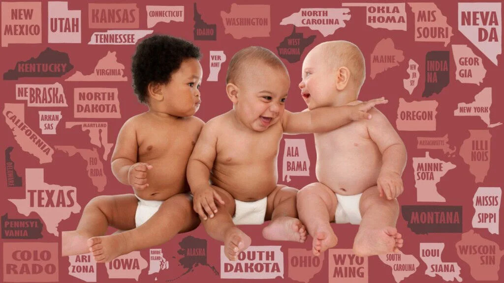 Here is your text with all single quote and double quote characters removed: Three babies in diapers sit before a backdrop featuring U.S. state names and shapes in red and pink hues—perfect inspiration for girl names or baby girl names. The baby on the right reaches out toward the center baby.