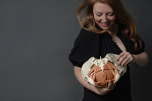 Dr. Krystal Lynn Couture looking down while holding a model pelvis