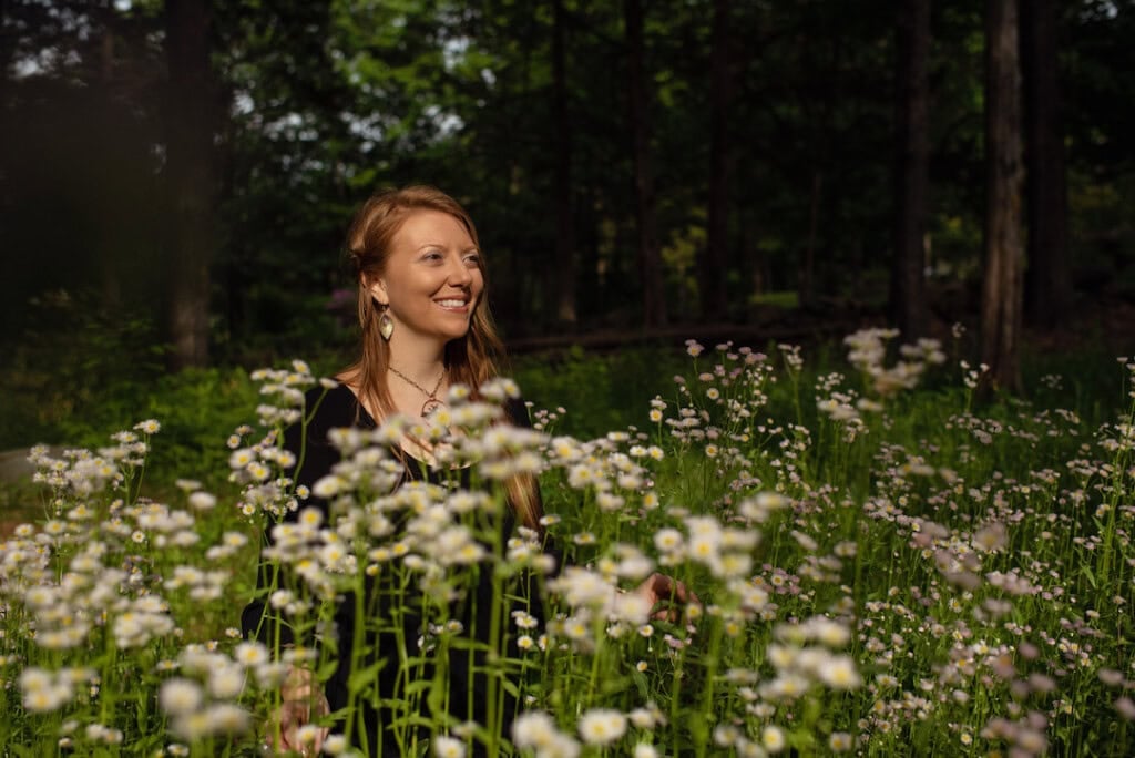 Dr. Krystal Lynn Couture outside in a field of wildflowers