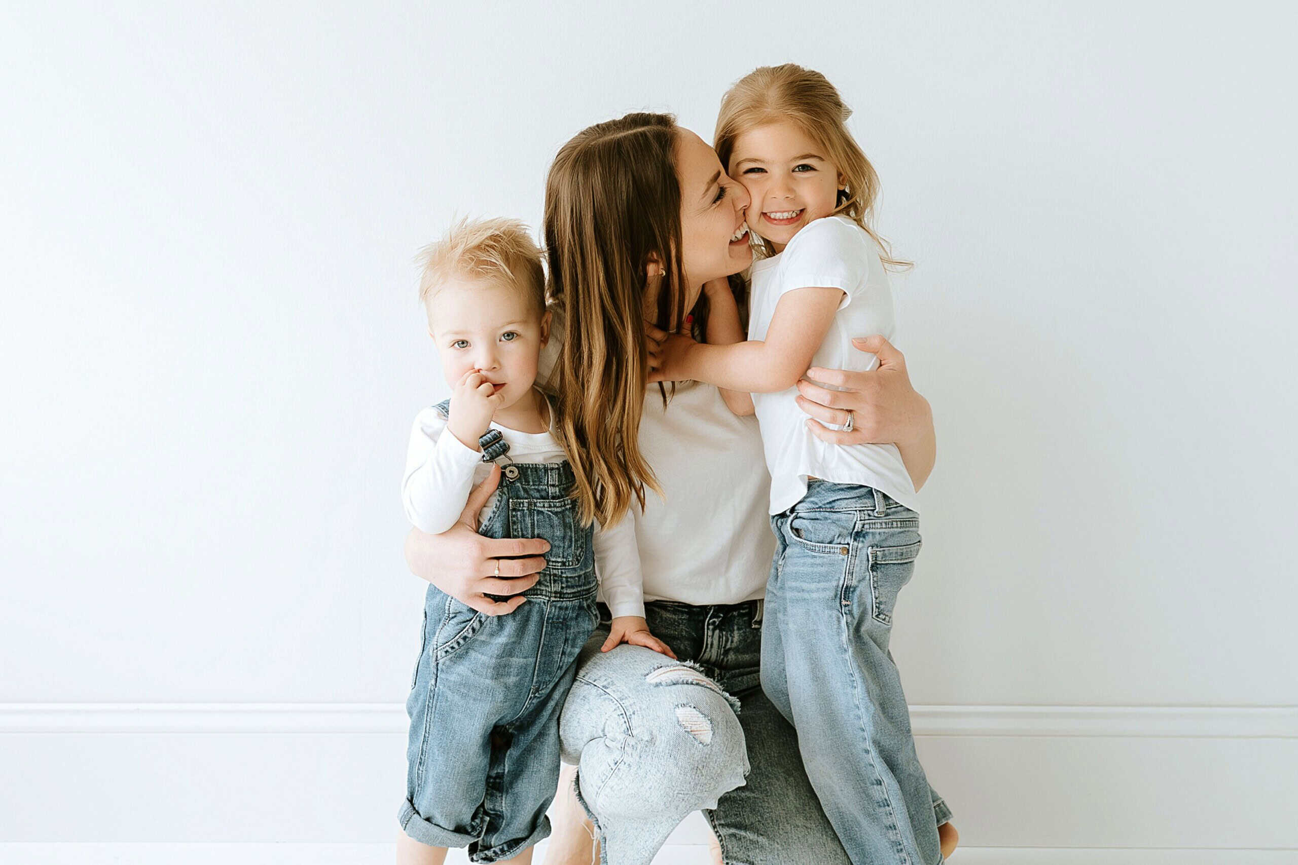 Adorable family embracing, smiling, and enjoying quality time together in a bright, minimalistic home.