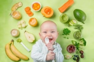 A happy baby surrounded by colorful fruits, vegetables, and homemade purees, promoting healthy eating habits.